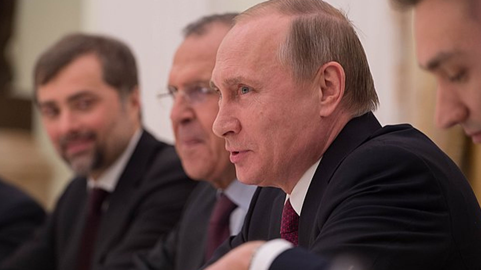 Vladimir Putin at a desk.