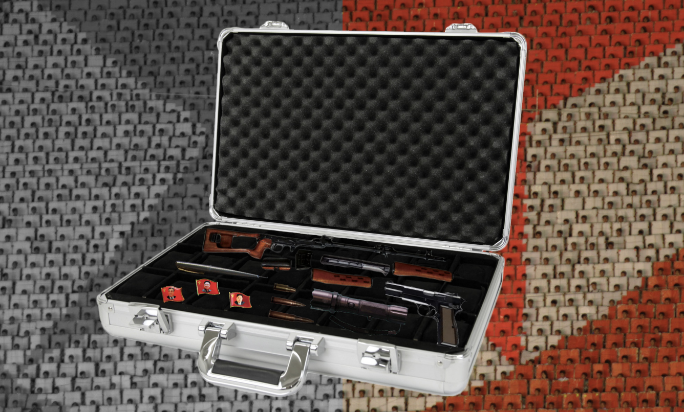 A briefcase with weaponry and DPRK leader pins atop a North Korean flag background.